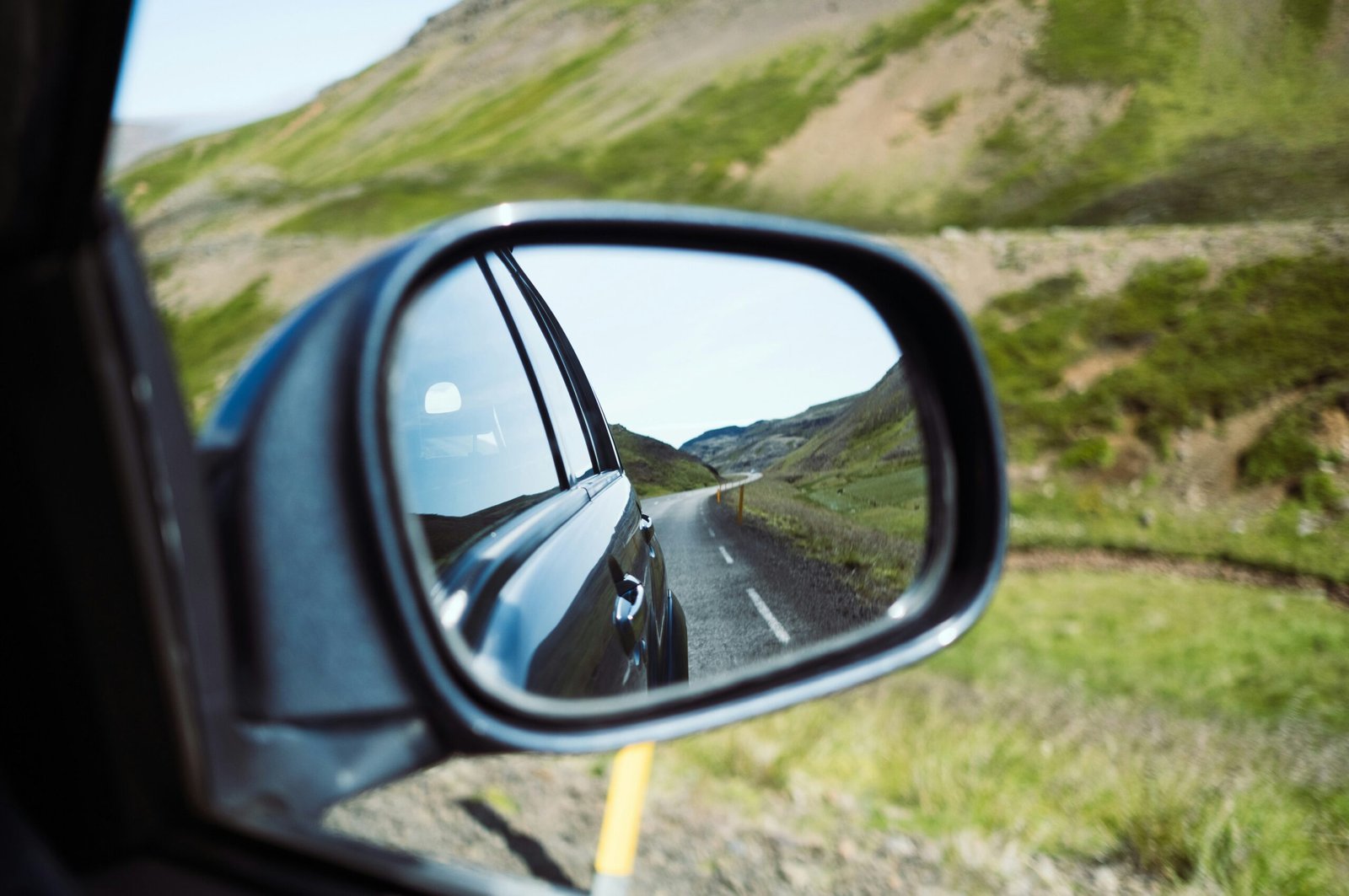 black car side mirror with water droplets